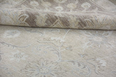 A handmade Afghan Chobi rug featuring a traditional floral pattern in neutral beige tones.