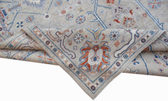 A handwoven Afghan Chobi rug featuring a light grey field with blue and rust floral patterns.