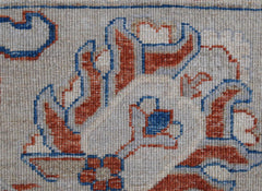A close-up of an Afghan Chobi rug featuring intricate floral patterns in rust and blue wool.
