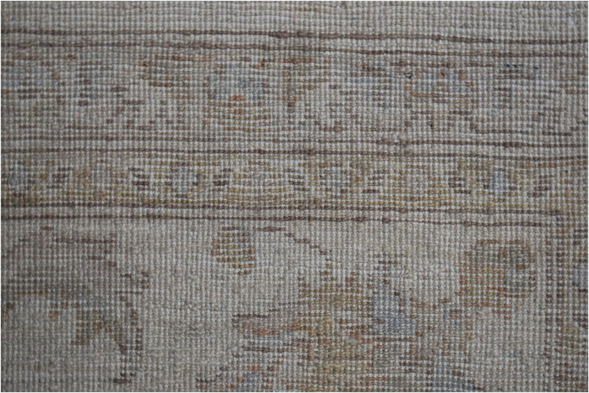 A close-up view of an Afghan Chobi rug featuring a neutral palette with subtle, earthy patterns.