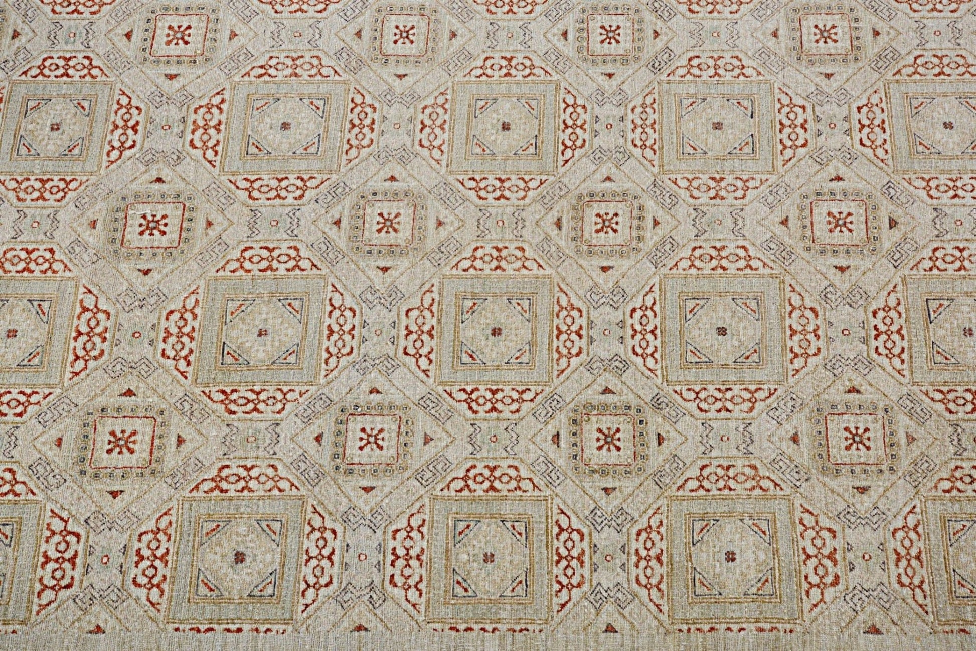 Handmade Afghan Chobi rug featuring a geometric pattern in earthy red and beige tones.
