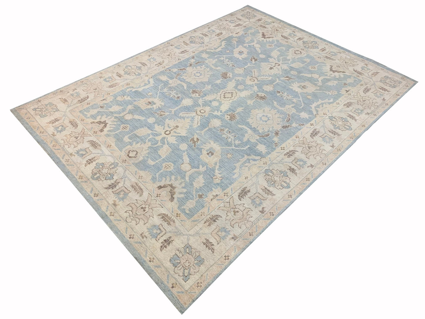 A handmade Afghan Chobi rug featuring a traditional floral pattern in shades of blue and beige.