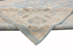 A handmade Afghan Chobi rug featuring a traditional floral pattern in soft blue and beige tones.