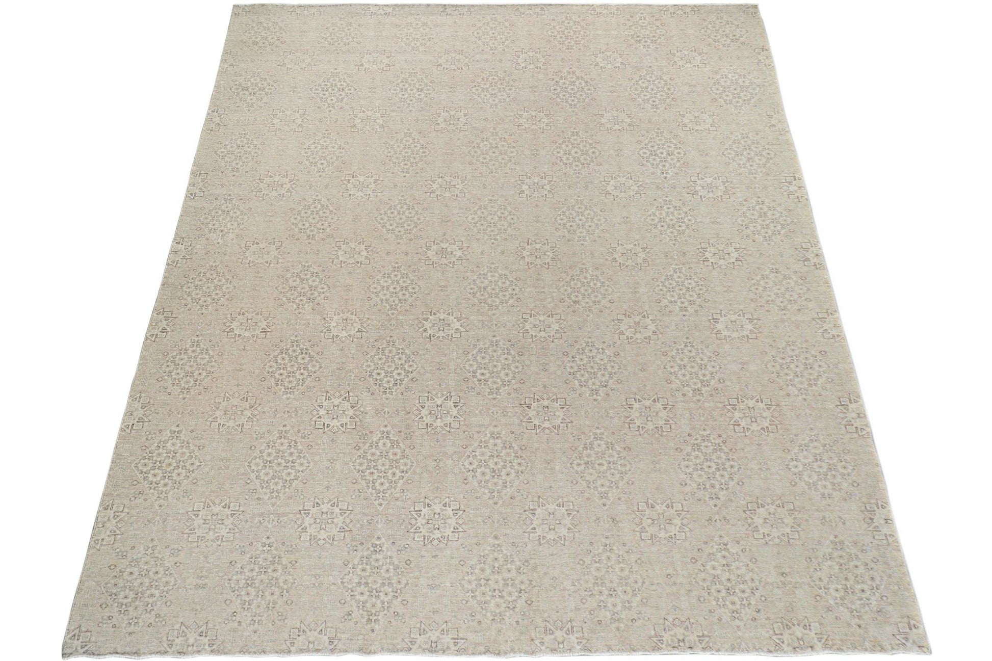 A handmade Afghan Chobi rug featuring a repeating geometric pattern in soft neutral tones.