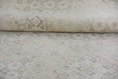 A handmade Afghan Chobi rug featuring a neutral cream palette with subtle geometric patterns.