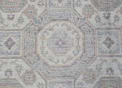 A handmade Afghan Chobi rug featuring a traditional geometric pattern in soft blue and beige tones.