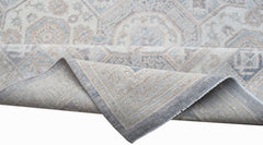A handwoven Afghan Chobi rug featuring a traditional geometric pattern in soft neutral tones.