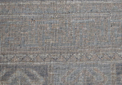 A close-up view of a handwoven Afghan Chobi rug featuring a textured, neutral-toned wool weave.