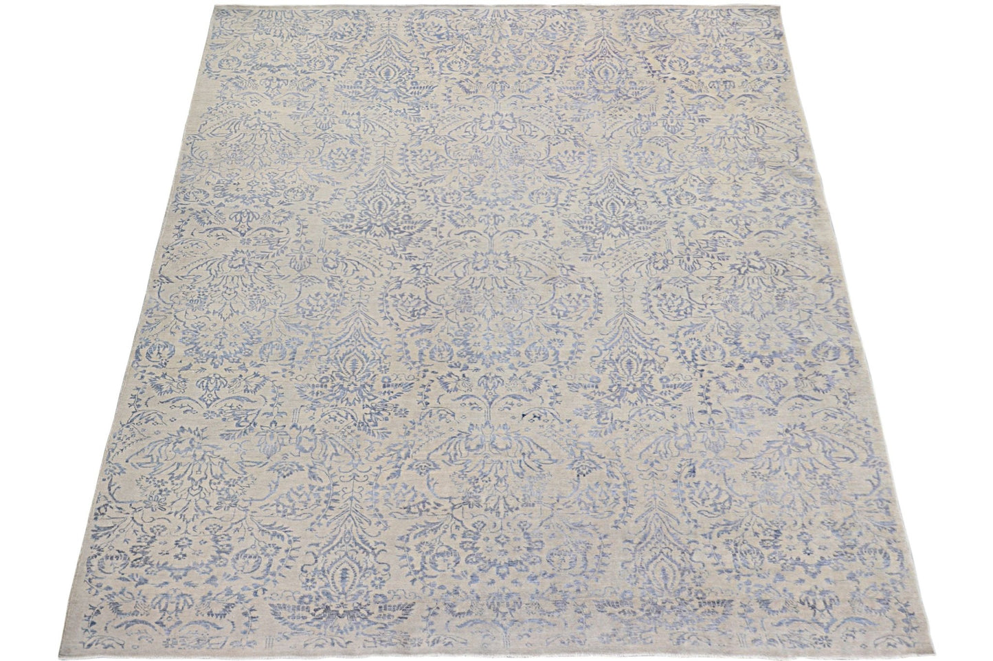 An Afghan Chobi rug featuring a traditional blue floral damask pattern on a light beige background.