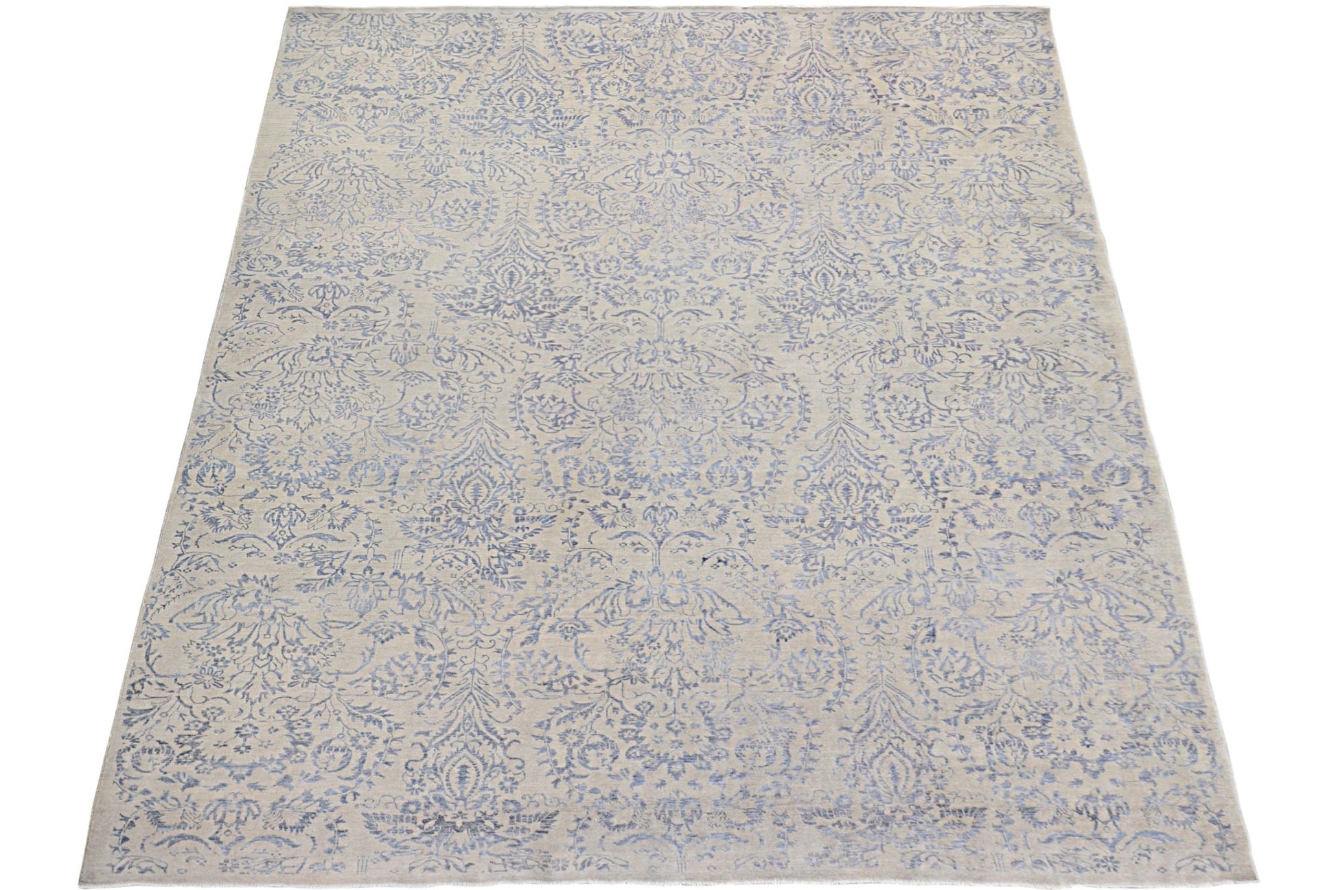 An Afghan Chobi rug featuring a traditional blue floral damask pattern on a light beige background.