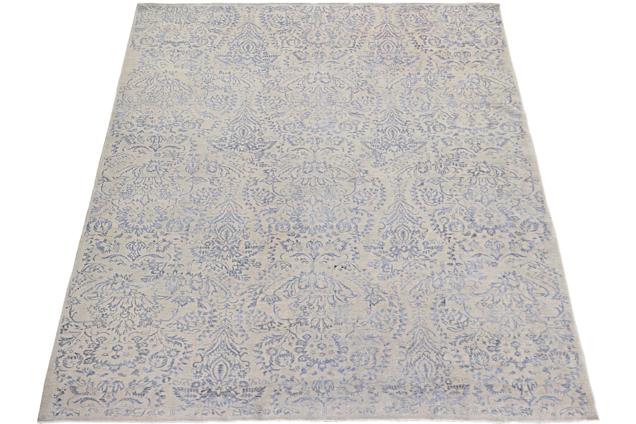 An Afghan Chobi rug featuring a traditional blue floral damask pattern on a light beige background.