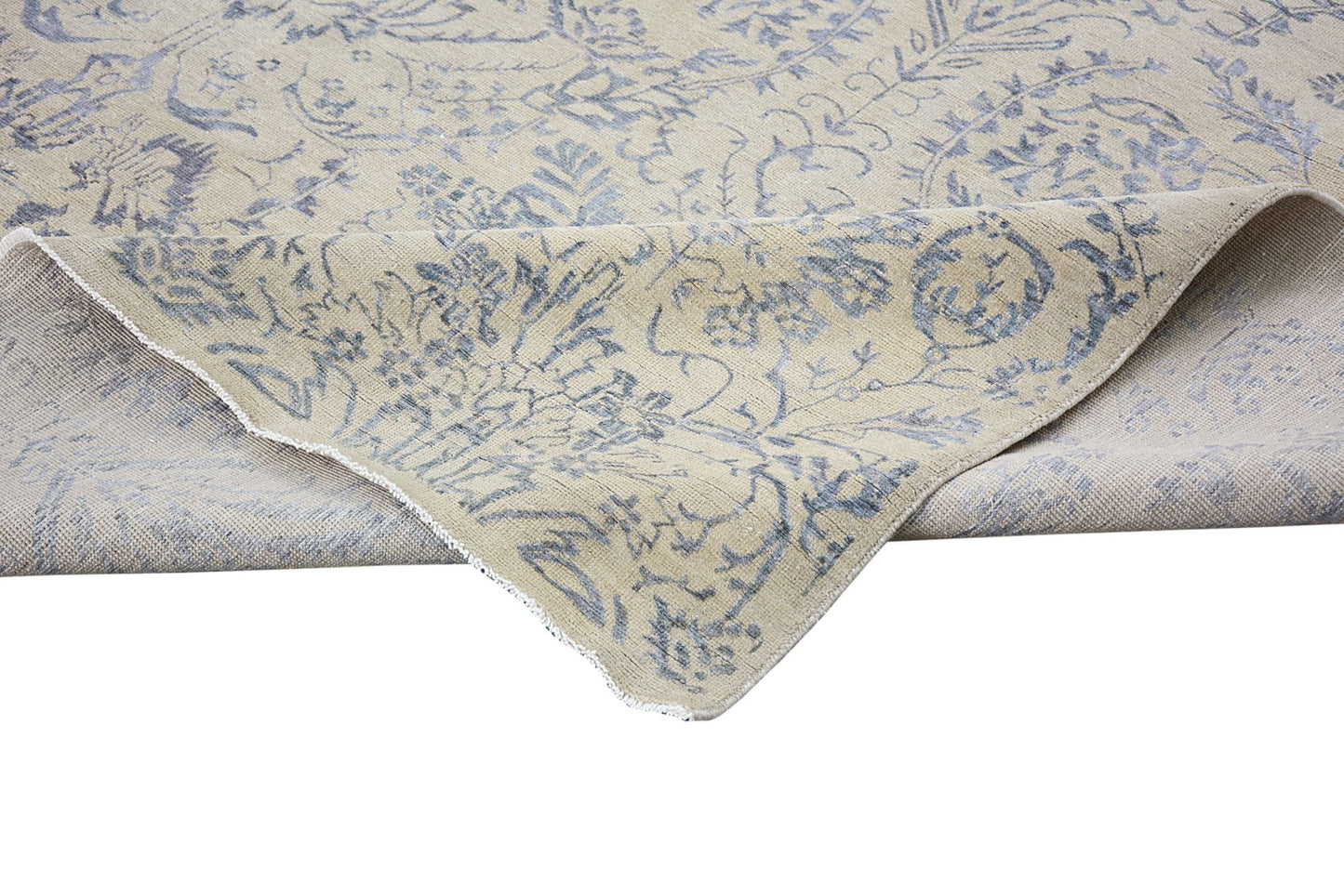 A handmade Afghan Chobi rug featuring a traditional blue floral pattern on a beige wool background.