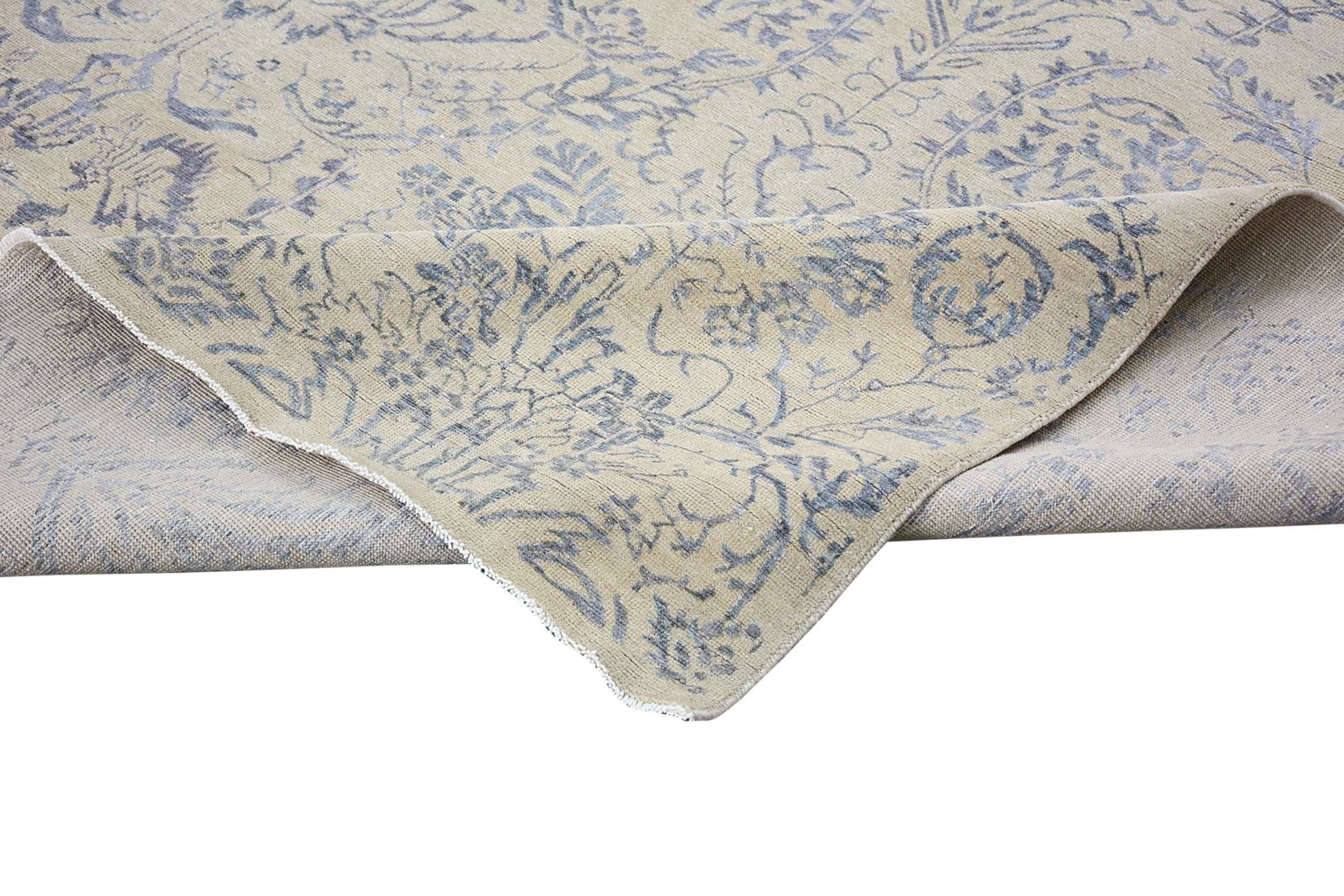 A handmade Afghan Chobi rug featuring a traditional blue floral pattern on a beige wool background.