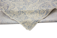 A handmade Afghan Chobi rug featuring a traditional blue floral pattern on a beige wool background.