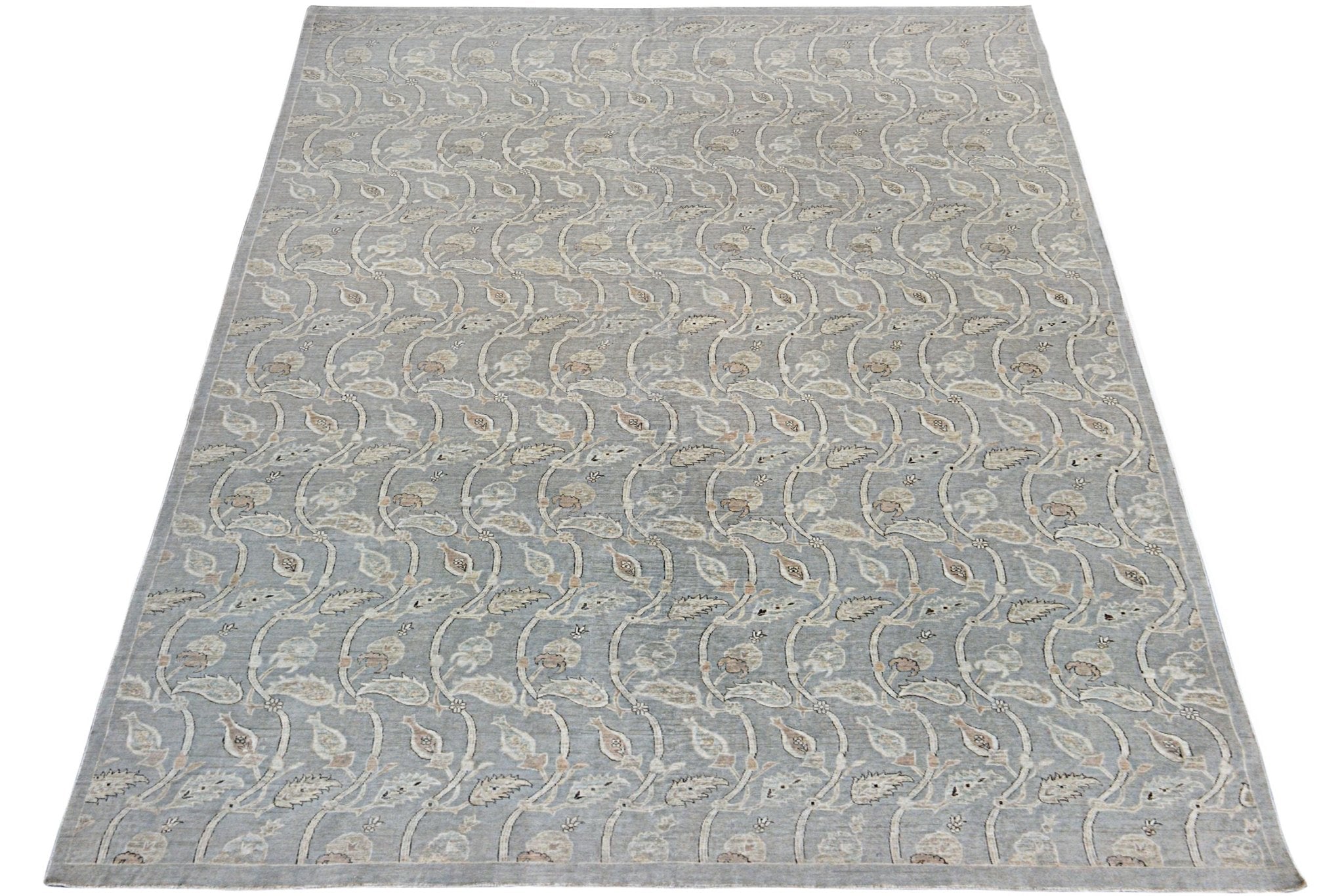 A handmade Afghan Chobi rug featuring a repeating floral vine pattern in soft grey and beige tones.