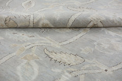 A handmade Afghan Chobi rug featuring a light grey and beige floral pattern on a wool pile.
