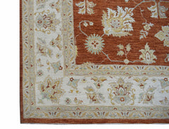 A handmade Afghan Chobi rug featuring a traditional floral pattern in rust and cream tones.