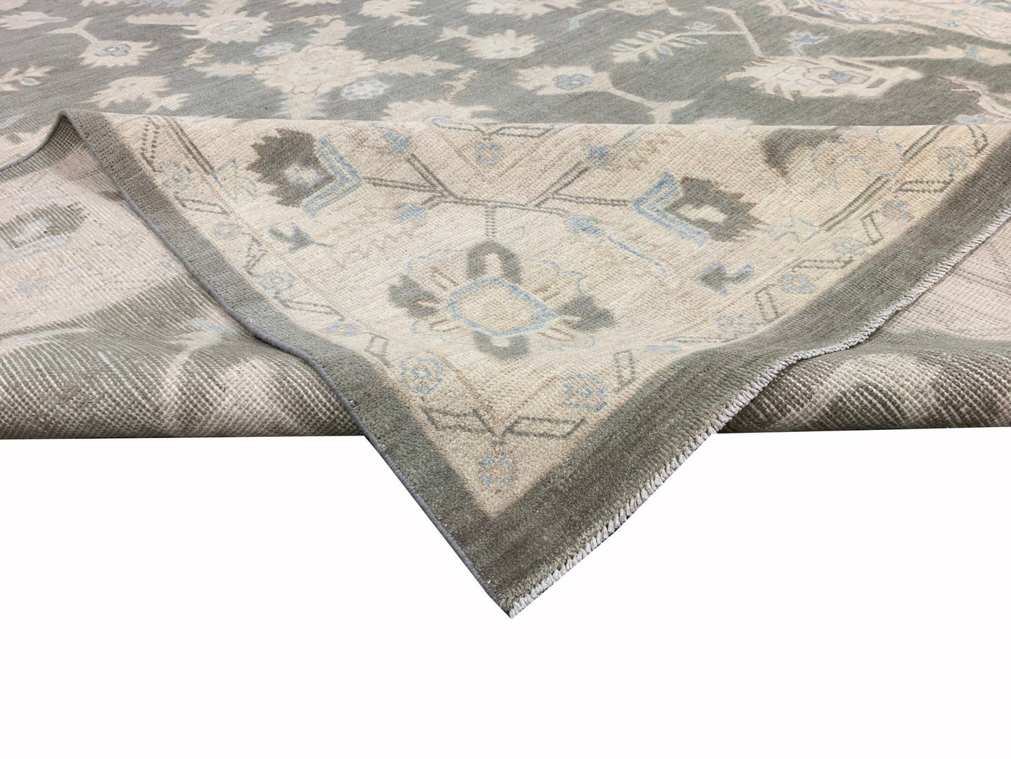 A handmade Afghan Chobi rug featuring a traditional floral pattern in grey and cream tones.