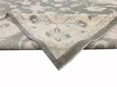 A handmade Afghan Chobi rug featuring a traditional floral pattern in grey and cream tones.