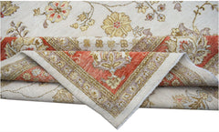 An Afghan Chobi rug with a cream field and floral patterns folded to show its red border.