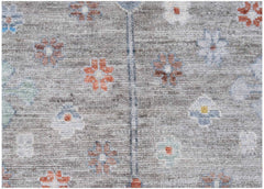 Handwoven Afghan Chobi rug featuring a grey field with small, colorful floral motifs.