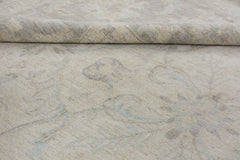 A close-up of a handmade Afghan Chobi rug featuring a subtle, light-toned floral pattern.