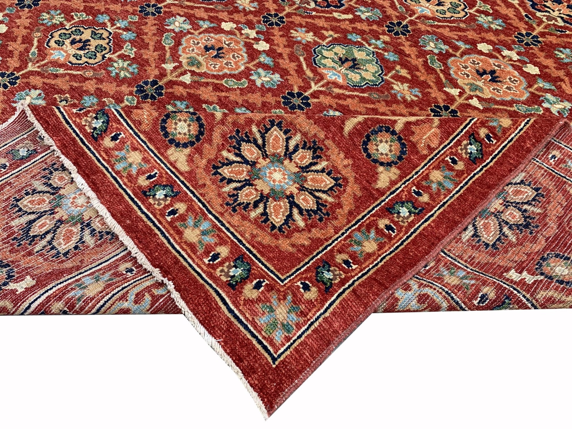 A handmade Afghan Chobi rug featuring a traditional floral pattern in warm red and blue tones.