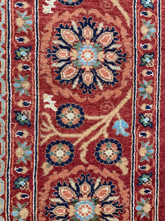 Handmade Afghan Chobi rug featuring intricate floral medallions in warm red and blue tones.