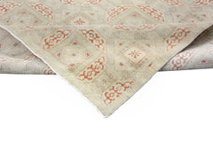 A handmade Afghan Chobi rug featuring a geometric pattern in soft beige and muted orange tones.