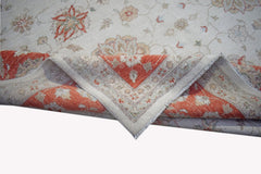 A handwoven Afghan Chobi rug featuring a floral pattern in orange and beige tones.