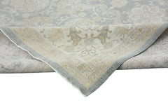 A handmade Afghan Chobi rug featuring a traditional floral pattern in soft blue and beige tones.