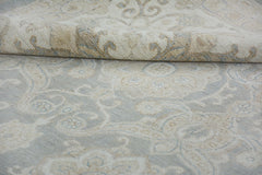 A handmade Afghan Chobi rug featuring a traditional floral pattern in soft beige and blue tones.