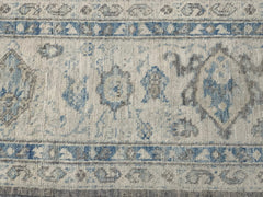 An Afghan Chobi rug featuring a traditional blue and grey floral pattern on a cream background.