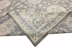 A handmade Afghan Chobi rug featuring a traditional floral pattern in shades of grey and blue.