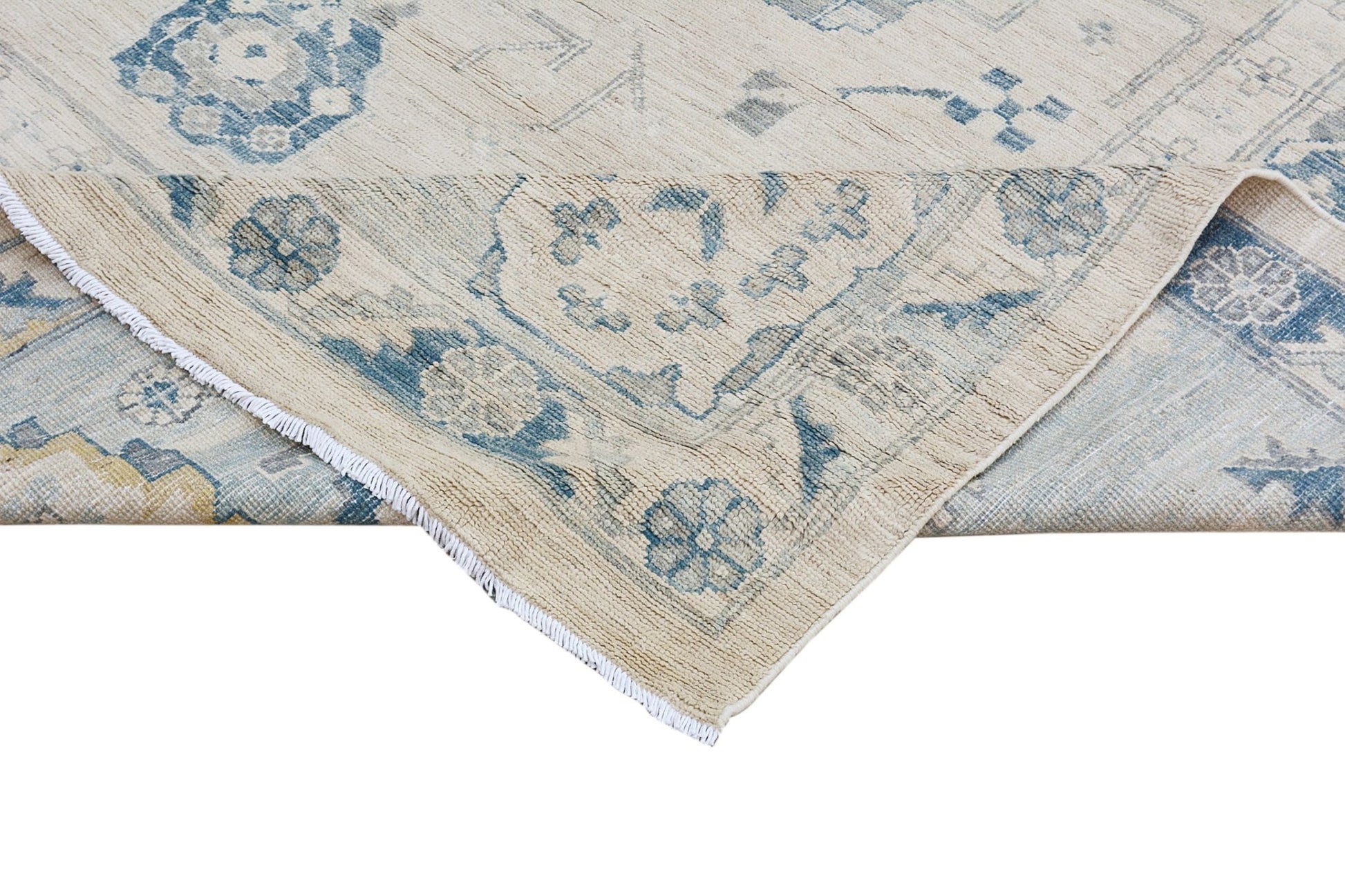 A handmade Afghan Chobi rug featuring a traditional floral pattern in blue on a cream background.
