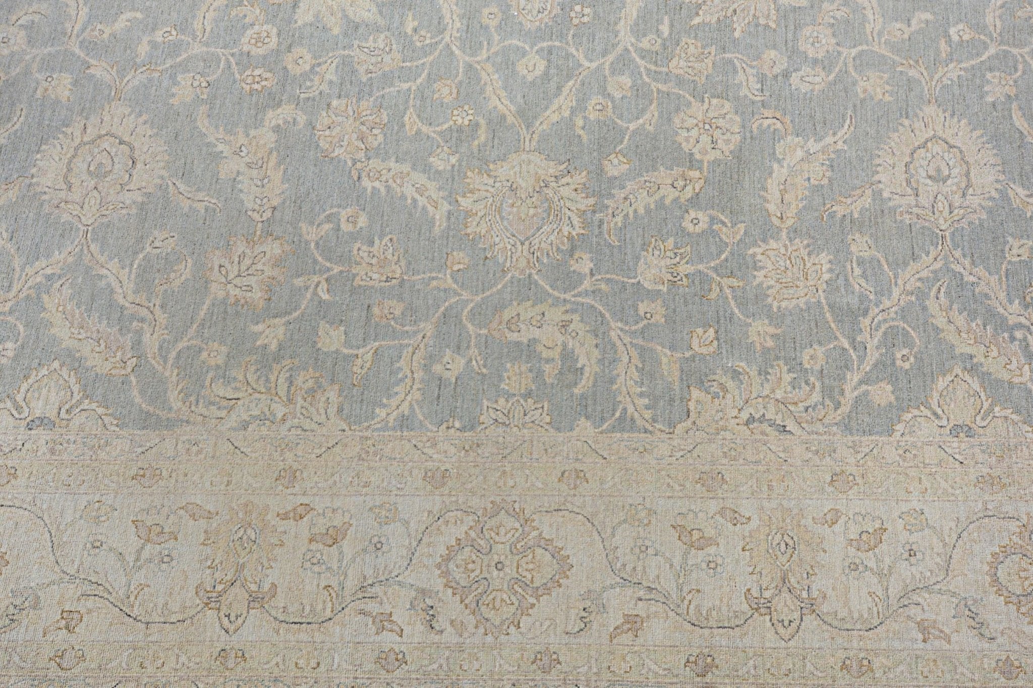 Handmade Afghan Chobi rug featuring a light blue field with intricate beige floral patterns.