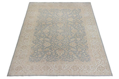 A handmade Afghan Chobi rug featuring a traditional floral pattern in soft blue and beige tones.