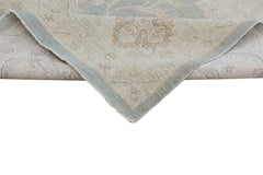 A handmade Afghan Chobi rug featuring a traditional floral pattern in soft beige and blue tones.