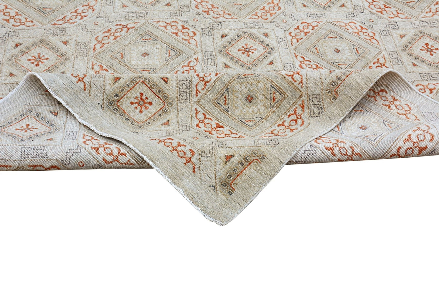 A handmade Afghan Chobi rug featuring a geometric pattern in earthy tones with a folded corner.