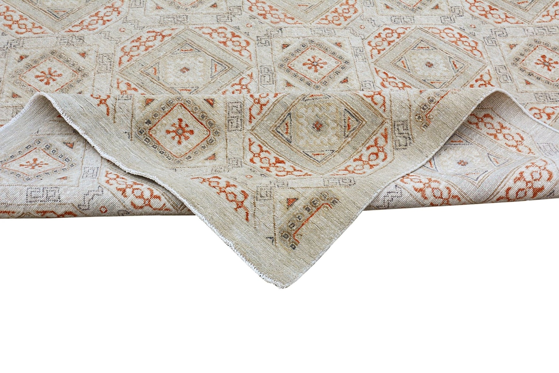 A handmade Afghan Chobi rug featuring a geometric pattern in earthy tones with a folded corner.