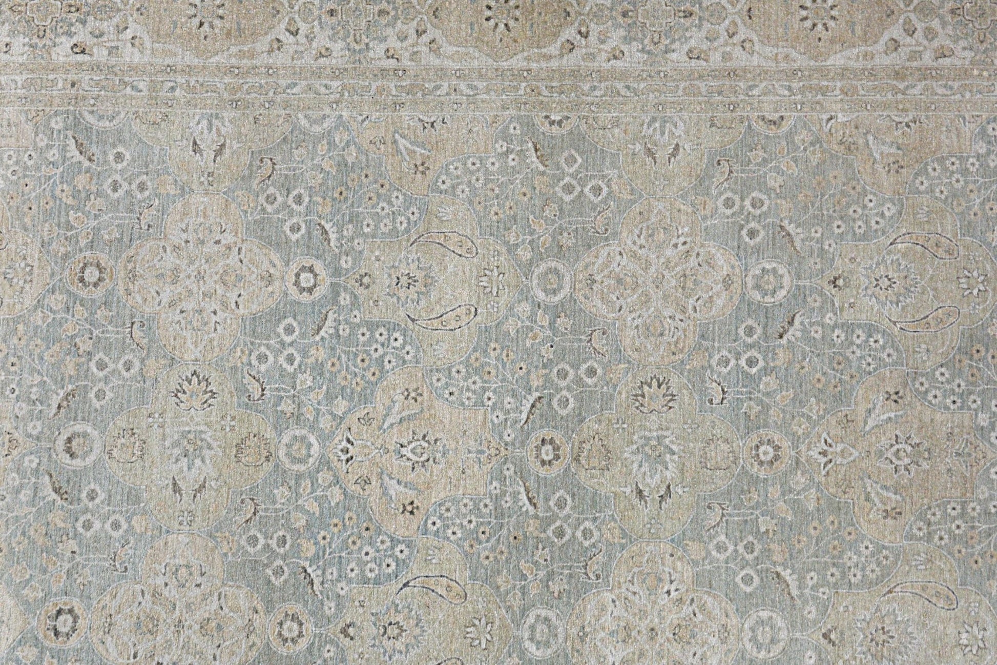 An Afghan Chobi rug featuring a traditional floral pattern in muted blue and beige tones.