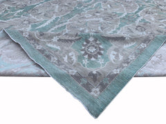 An Afghan Chobi rug featuring a traditional floral pattern in shades of teal, grey, and cream.