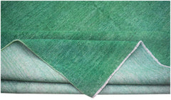 A handwoven Afghan Chobi rug in a solid, overdyed green hue with a visible cotton foundation.
