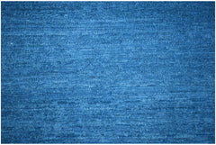 A handwoven Afghan Chobi rug featuring a textured, solid blue wool surface.