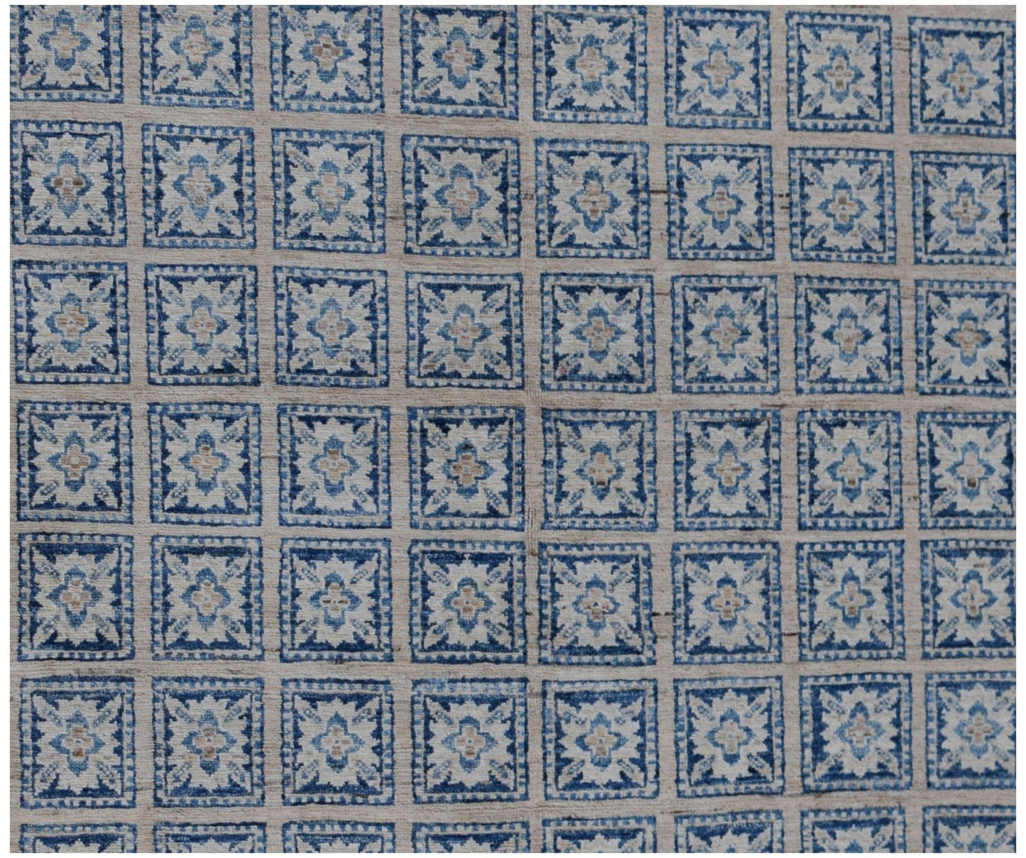Handmade Afghan Chobi rug featuring a repeating grid of blue and cream floral motifs.