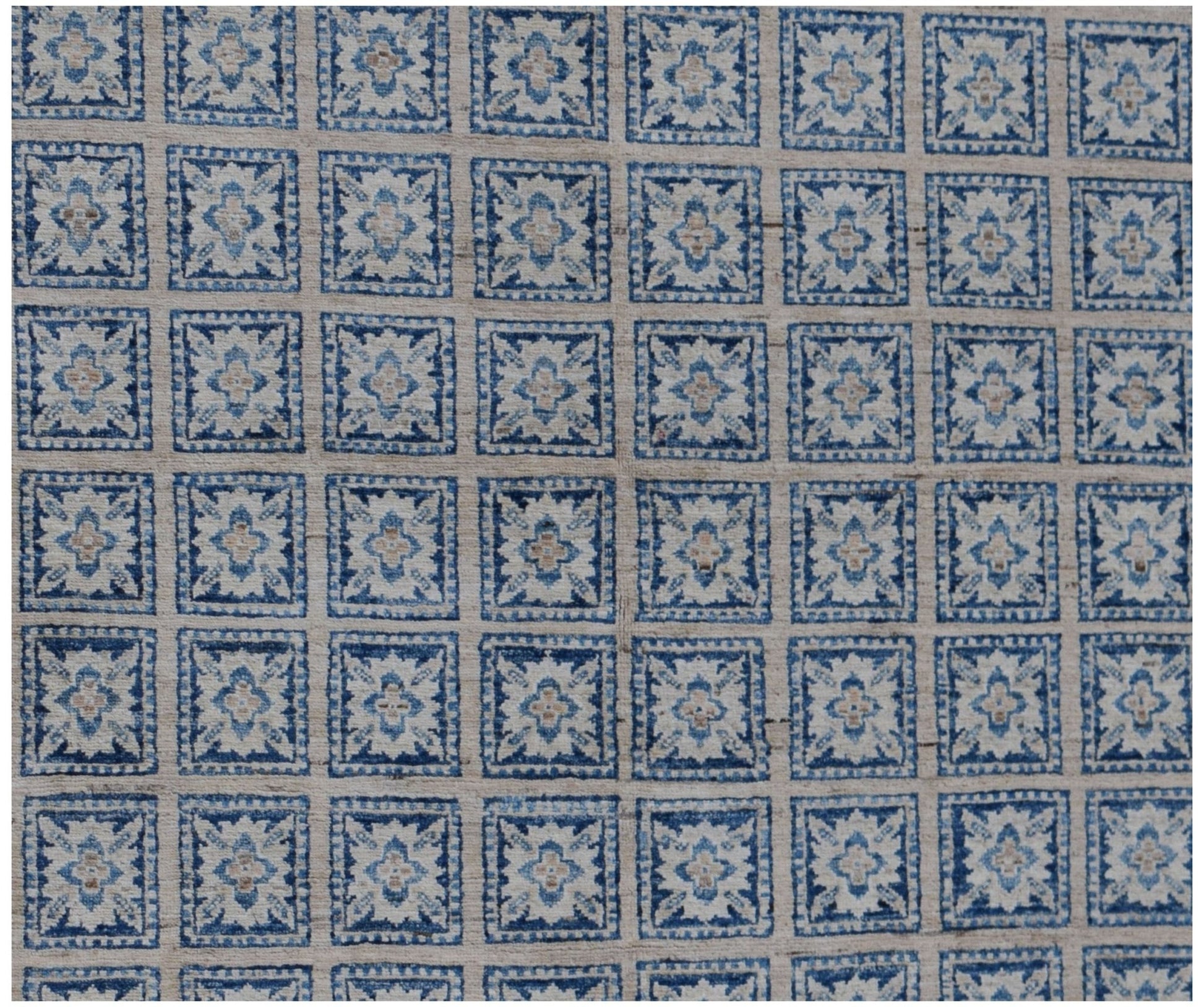 Handmade Afghan Chobi rug featuring a repeating grid of blue and cream floral motifs.