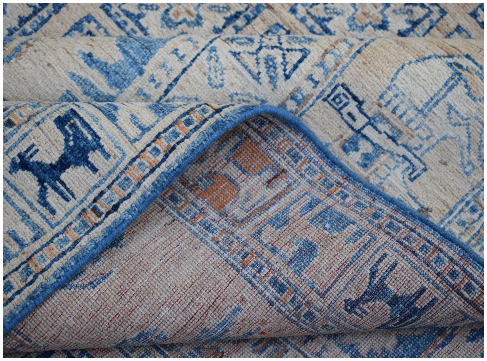 A handmade Afghan Chobi rug featuring a blue and cream Pazyryk-inspired geometric pattern.