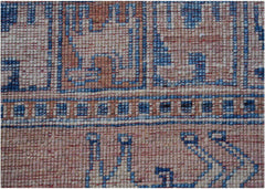 A close-up of a handmade Afghan Chobi rug featuring geometric patterns in blue, beige, and grey.