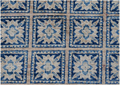 An Afghan Chobi rug featuring a repeating grid of blue and cream geometric floral motifs.