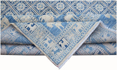 A blue and cream Afghan Chobi rug featuring a geometric diamond pattern and animal motifs.